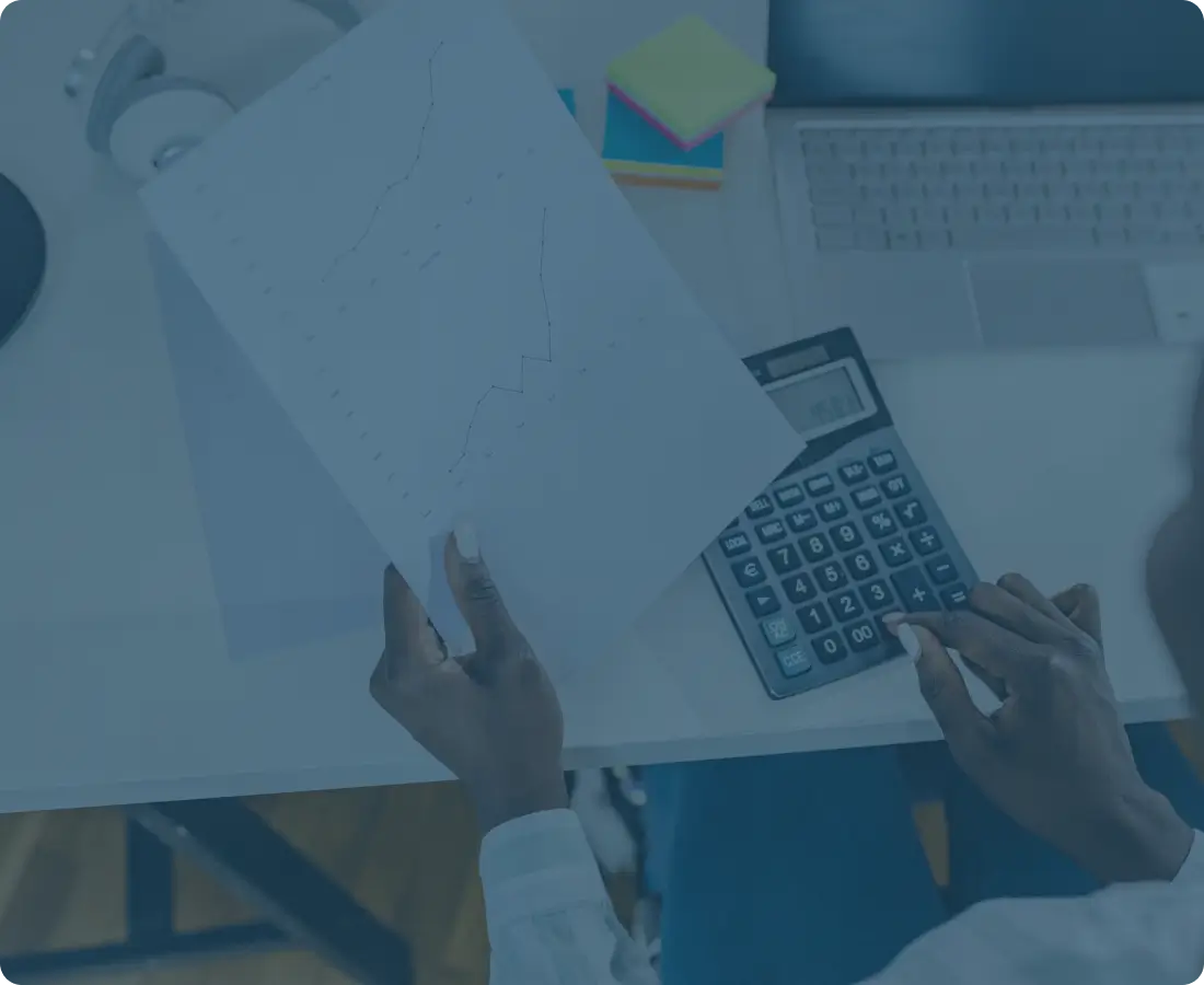 Person calculating with paper, calculator, and laptop.